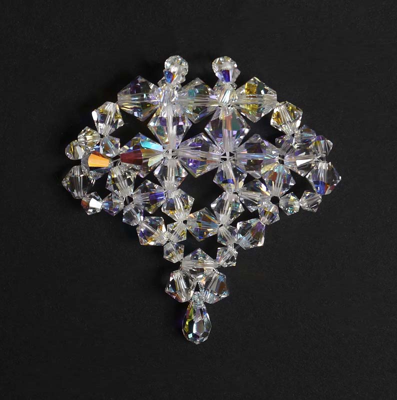 Duża zawieszka w kształcie serca, upleciona z różnej wielkości kryształów bicone crystal AB. Na dole kryształ w kształcie łzy.